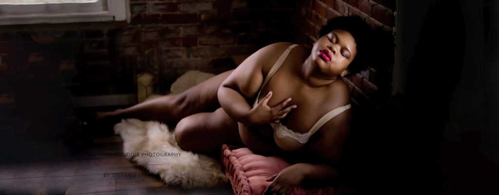 black plus-sized woman in lingerie posing for a ma boudoir photographer