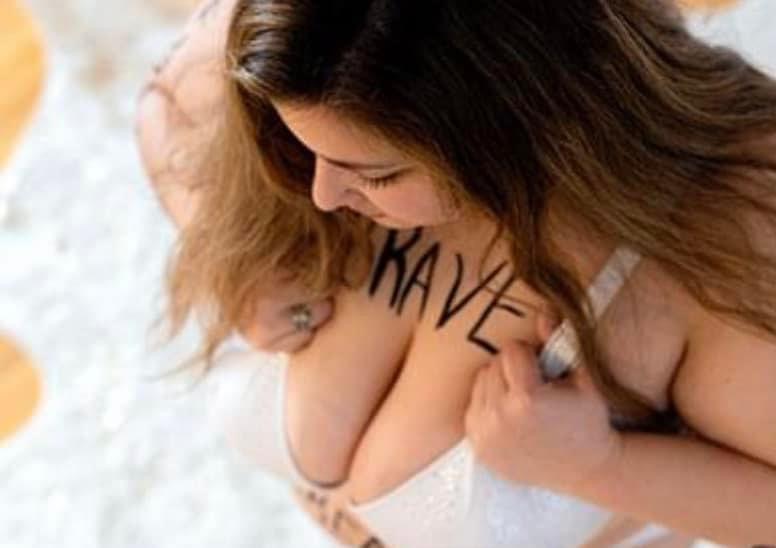 Girl with white bra looking down with the word brave written on her chest