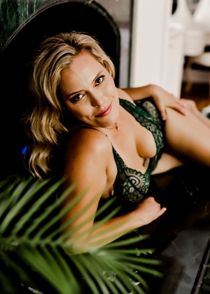 Woman with blonde hair wearing green lingerie for her Massachusetts Empowerment Boudoir experience