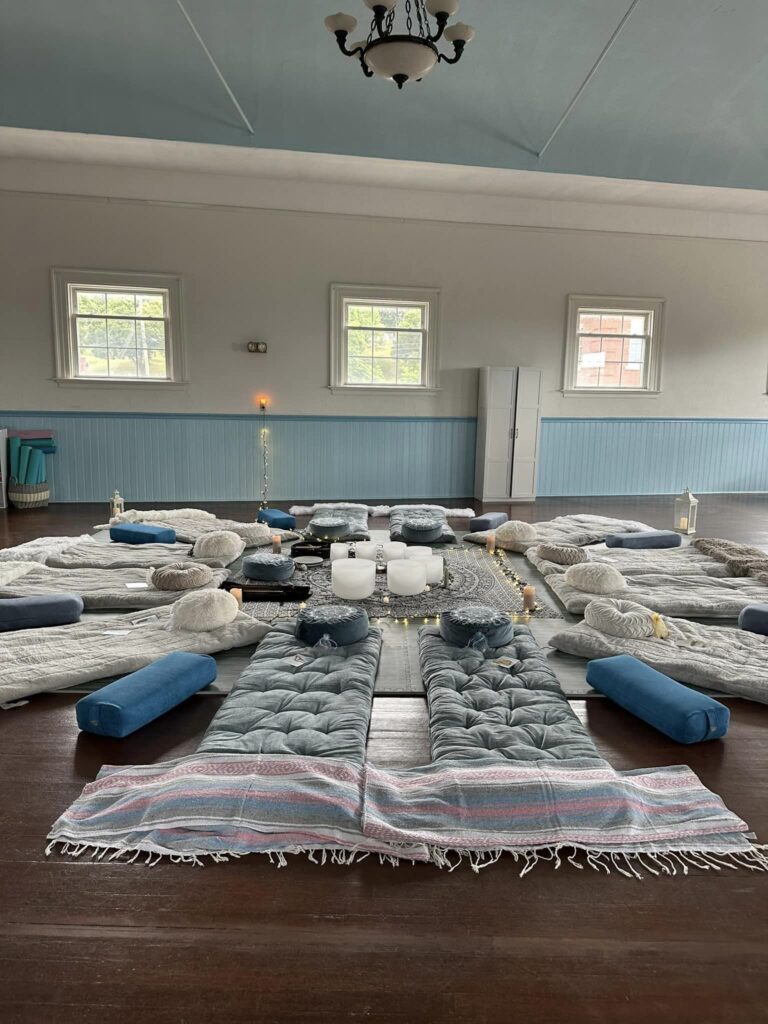 Mind Balance and wellness center's large open room with mats & cozy blankets & pillows on the floor for a sound bath event