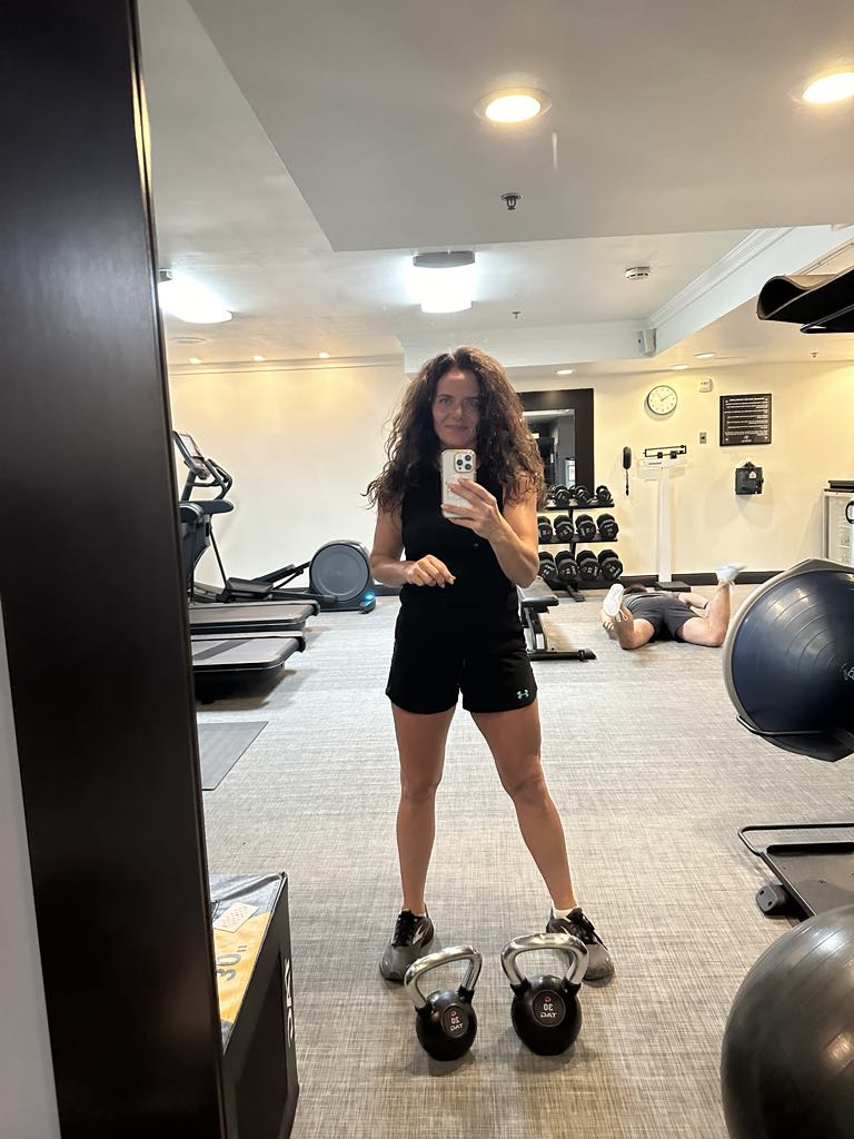 woman working out in a gym with kettle bells 