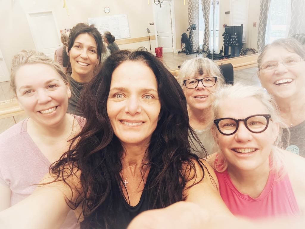 Mia, the personal trainer, in a group photo with 5 of her women clients