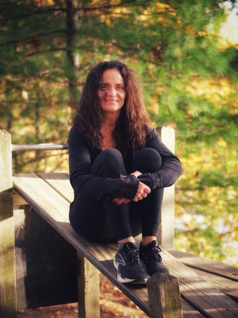 Mia the personal trainer sitting on a bench in workout clothing