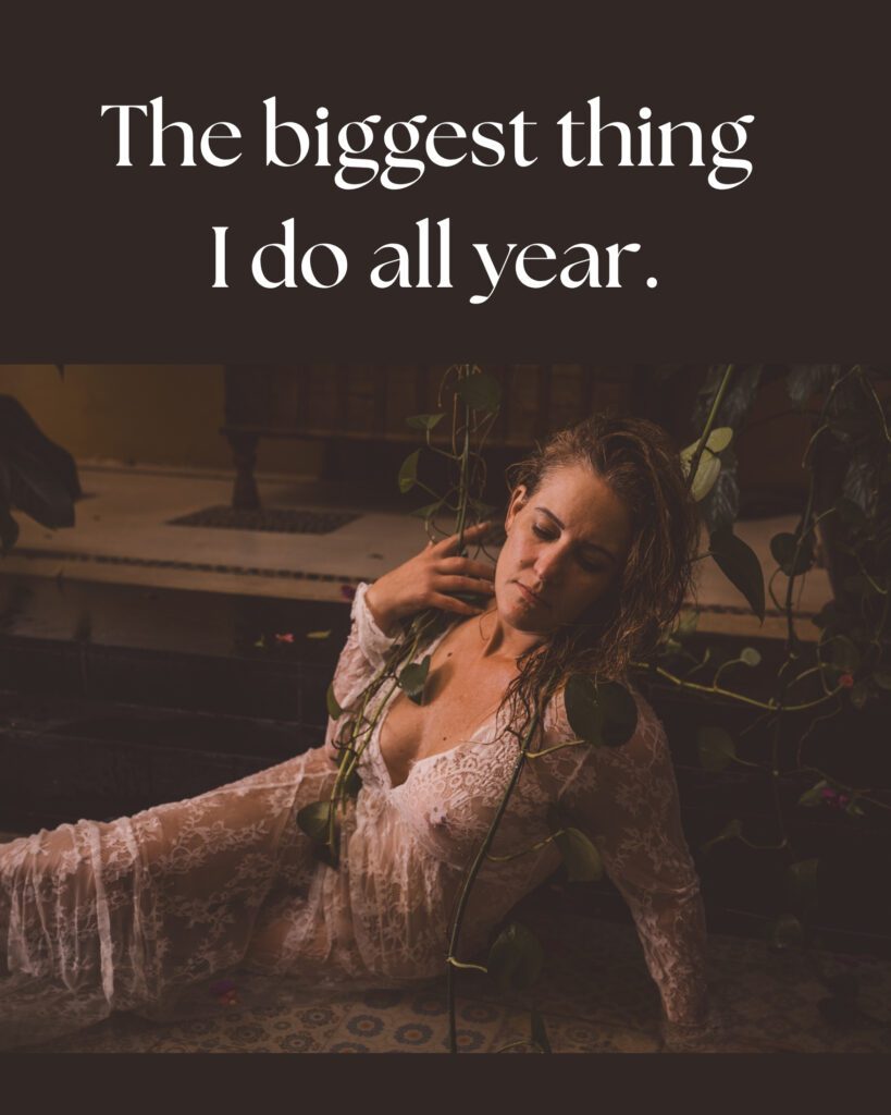 A Woman wearing a cream lace dress is lying in a shallow pool with vines surrounding her posing for south shore boudoir photographer