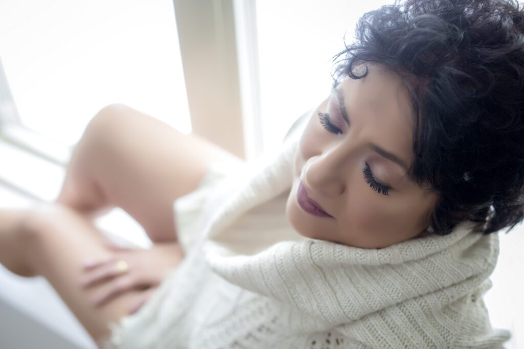woman in white sweater feeling safe at boudoir photography session