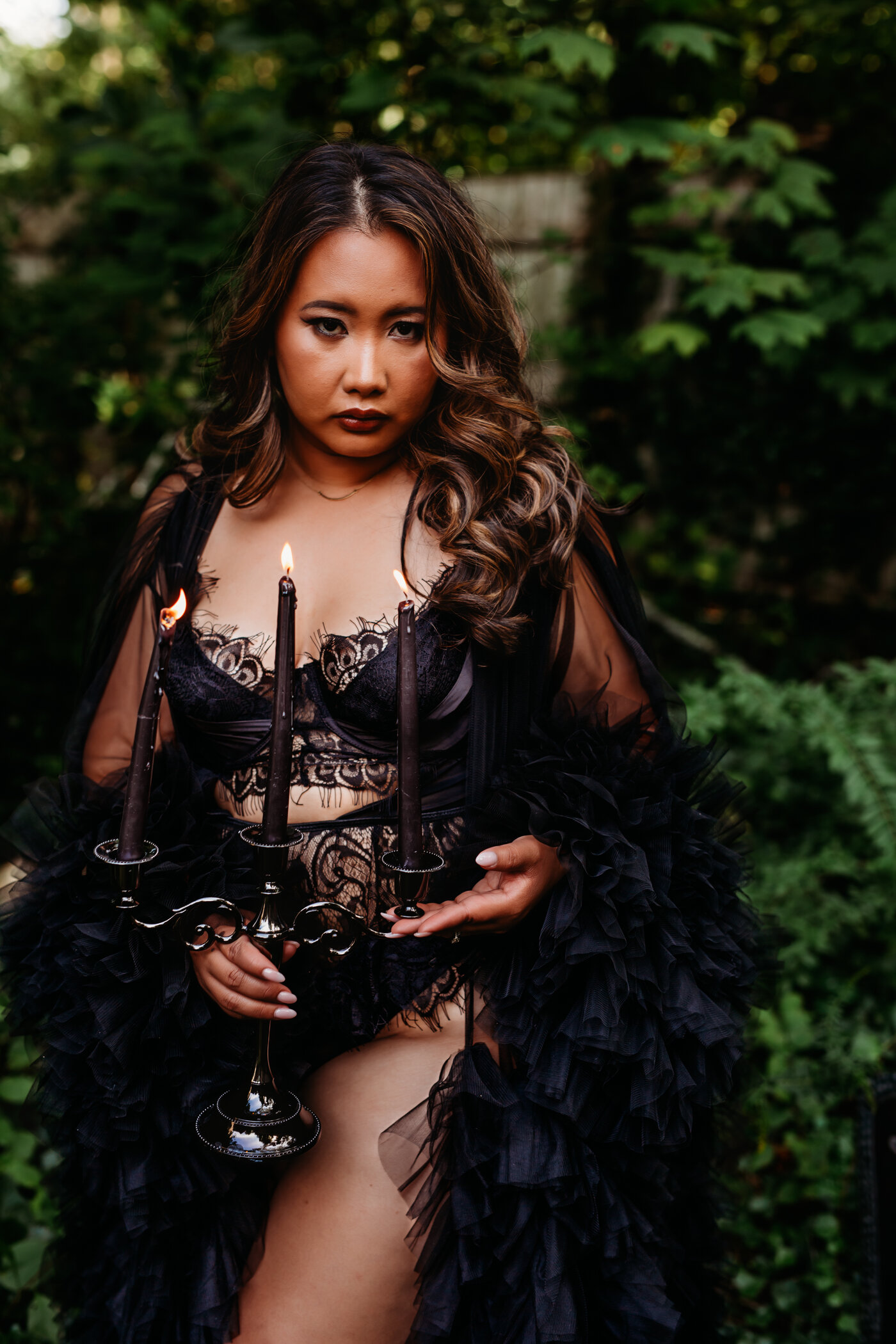 gothic woman holding candelabra in garden